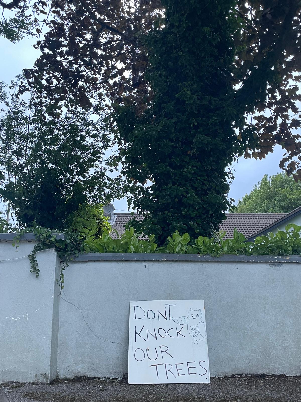 Don't knock our trees sign against a garden wall
